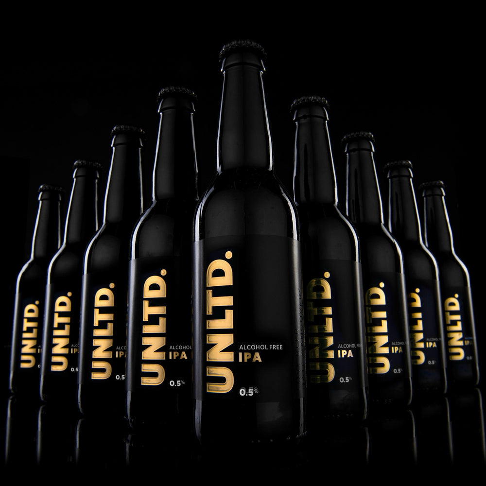 Row of black bottles with 'UNLTD.' branding on a dark background